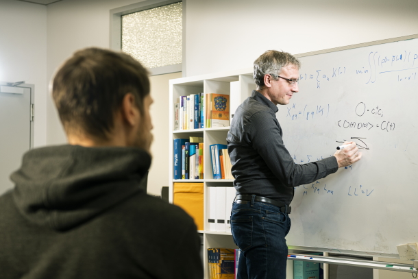 Dr. Michael Marthaler erklärt eine Formel an einem Whiteboard