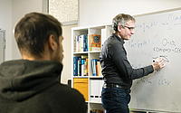 Dr. Michael Marthaler erklärt eine Formel an einem Whiteboard