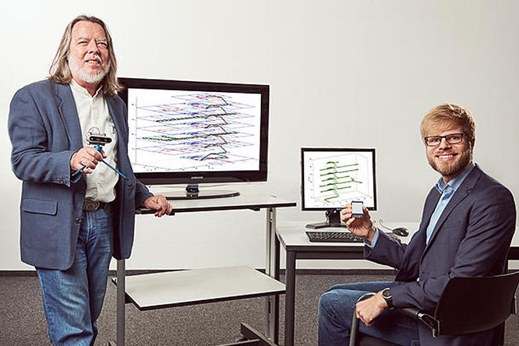 Professor Gert Trommer und Nikolai Kronenwett vor Computern mit dem Ortungssystem.