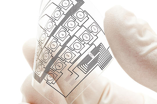 Hand hält gedruckte Elektronik.
