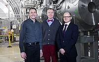 Projektleiter Michael Börsch und Geschäftsführer Fridolin Holdener von der WEKA AG mit Prof. Steffen Grohmann in der Halle des KATRIN-Experiments.