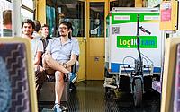 Der Lastenanhänger von regioKArgoTramTrain fährt in der Bahn mit. Links von ihm sitzen Passagiere auf ihren Plätzen. 